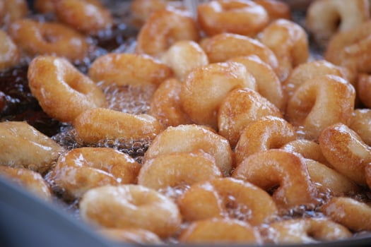 Freshly cooked turkish donuts frying in hot oil at a local fair photo