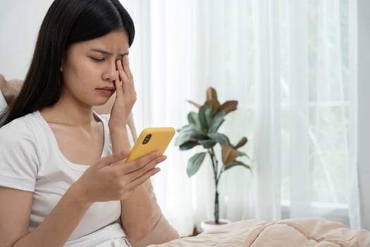 Eye problems, Asian women use hand cover eyes due to eye irritation, eye rubbing, dry, eye pain after look mobilephone long time, migraine, headache, blurred vision, photophobia, small words photo
