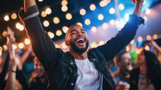 Jubilant male concert goer raising arms, celebrating pulsing music amid electrifying nighttime performance energy photo