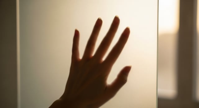 Touching the Unknown A Hand Silhouette Pressed Against Frosted Glass with Dreamy, Ethereal Light, Suggesting Connection and Longing photo