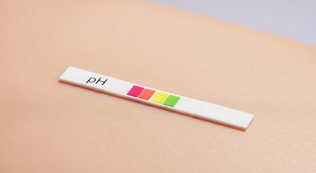 Close-up of a pH test strip placed on human skin, showing the measurement of skin acidity or balance, indicating healthy dermatological conditions or skincare evaluation. photo