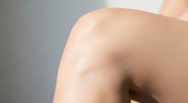 Close-up shot of a person's skin, showcasing smooth and healthy texture, with highlights and soft lighting. photo