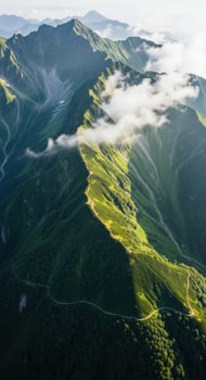 Sunlight illuminates a lush green mountain range with clouds photo