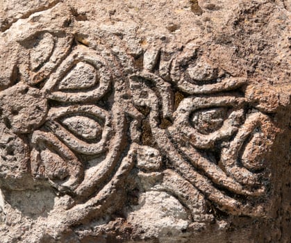 fragment of an ancient pattern carved into stone, textured background photo
