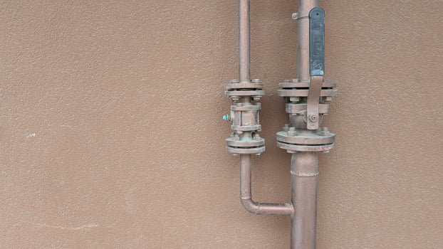 Various Industrial Pipes Equipped with Valves Mounted on the Vertical Wall Surface photo