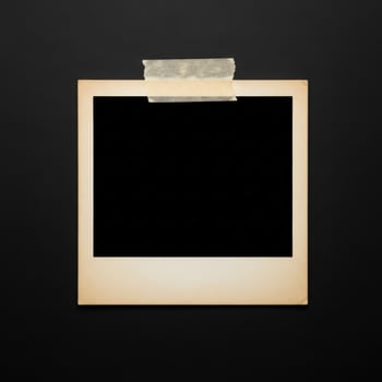 Vintage instant photo frame with tape on a dark background