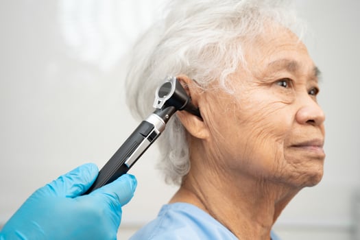 Otolaryngologist or ENT physician doctor examining senior ear otoscope photo