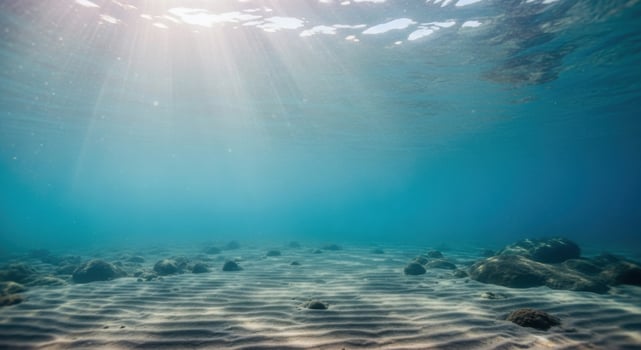 Sunlight filtering through the ocean water to the sandy seabed photo