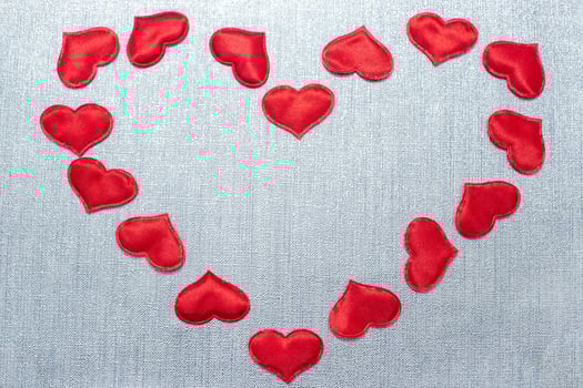 red hearts laid out in the shape of a big heart on a silver background photo