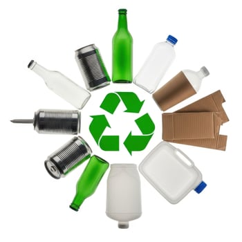 Green recycling symbol surrounded by glass bottles aluminum cans and cardboard sustainability reuse photo