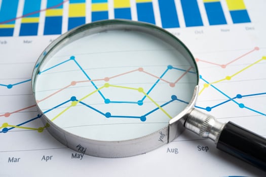 Magnifying glass on data graphs photo