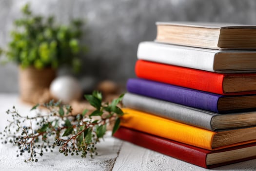Books arranged in rainbow order on a clean white desk photo
