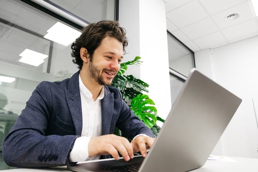 Young man in a business suit working on a laptop in the office. Concept of professionalism and productivity. photo