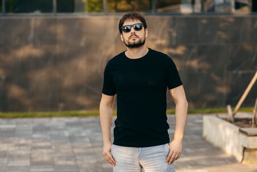 Adult stylish man with a beard in a black T-shirt and glasses photo