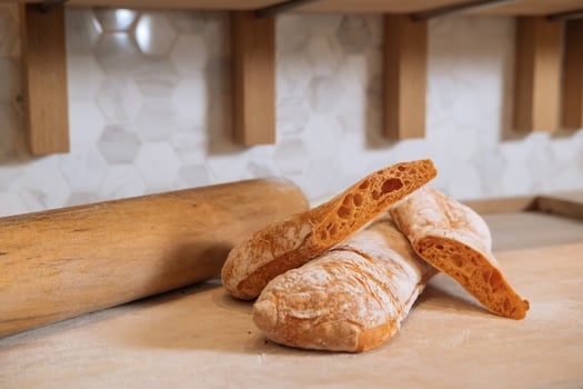 Ciabatta Bread with a Hint of Tomato isolated on Wooden background closeup side view of italian Baked Food photo