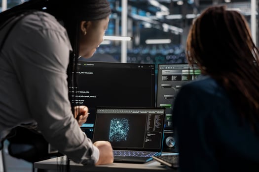 Data center engineering team using artificial intelligence visualization tools on device to identify errors. Teamworking server hub colleagues look at insights to detect hardware failures photo