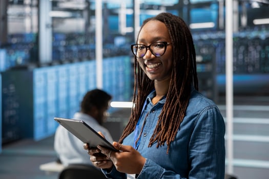 Smiling server hub IT specialist troubleshoots gear issues. Portrait of radiant data center system administrator using tablet to monitor equipment performance, identifying bottlenecks. photo