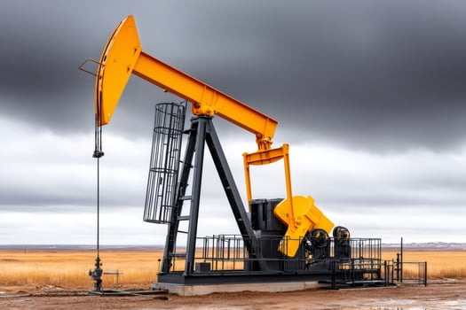 Pump jack extracting crude oil on a cloudy day photo