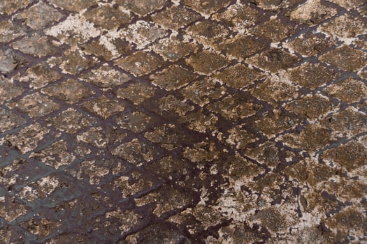 Close-up of textured rusty metal with diamond pattern and aged industrial surface in brown and beige photo