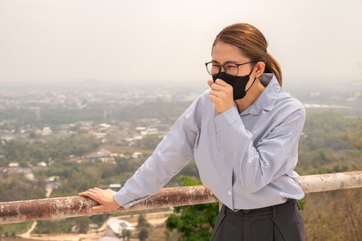 Young Asian businesswoman coughing becaused of allergy from Bad air pollution. photo