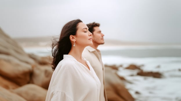 Couple meditating by the ocean photo