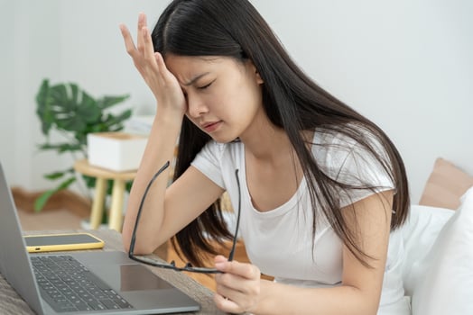 Eye problems,. Asian women with tired and irritated eyes, eye rubbing, dry, eye pain after work, migraine, headache, blurred vision, photophobia, working in the dark, blue light from computer photo