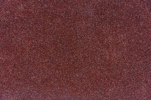 Close-up texture of red granular roofing surface with mineral coating for waterproofing, durability photo