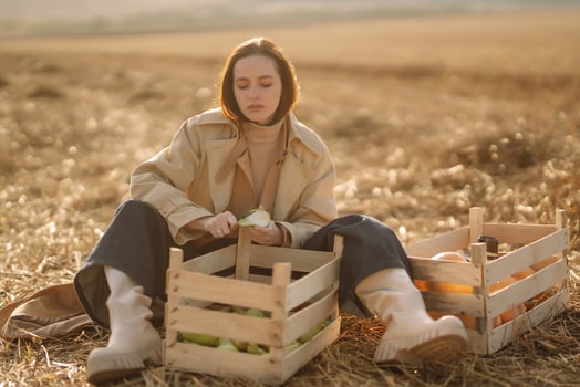 Woman in coat photographing the autumn harvest on a field photo