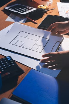 A person is working on a blueprint on a table photo