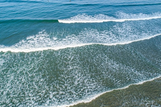 Drone view of the surf on a sunny day, a peaceful and scenic seascape. photo