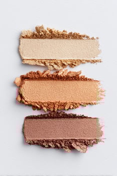 Three layers of eyeshadow in neutral shades displayed on a white background showcasing color diversity and texture photo