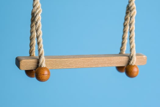 A wooden swing on a blue background photo