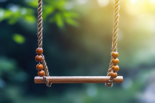A wooden swing hanging from a rope photo