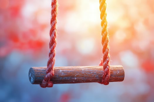 A wooden swing with red rope hanging from it photo