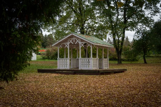 Rustic Gazebo in Autumn Park Surrounded by Trees photo