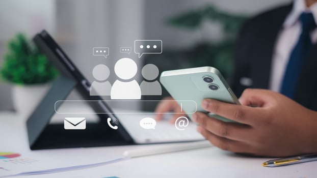 Businessman using smartphone with email, phone, chat and group icons, digital communication and online customer support concept in office setting. photo