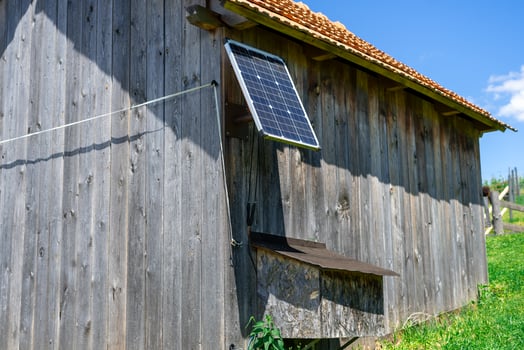 View of a small solar panel installed on a rural barn of a small farm, producing electricity. Ecological electricity production photo