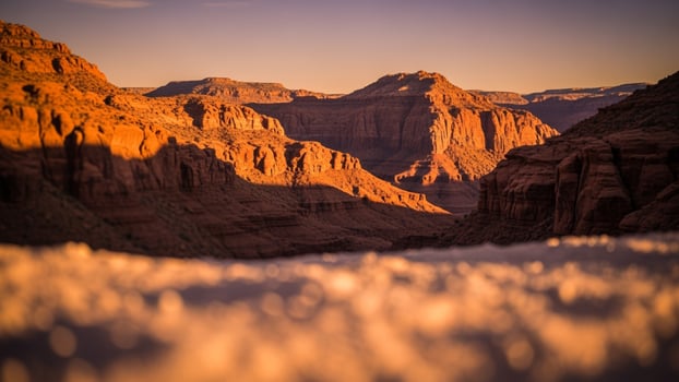 The sun is setting over the canyon in the background photo