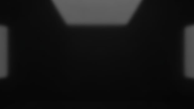 A black and white photo of a room with a light coming from the windows