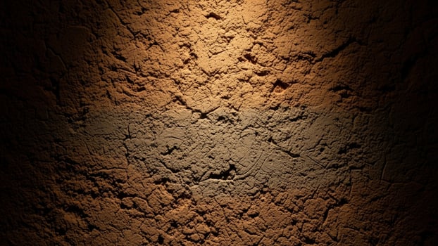 A dark brown wall with a light coming from it photo