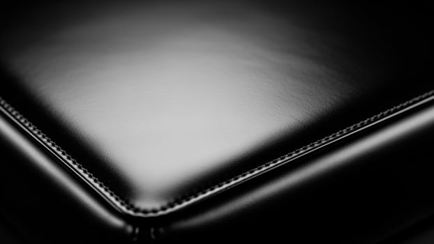 Black leather sofa with a black background photo