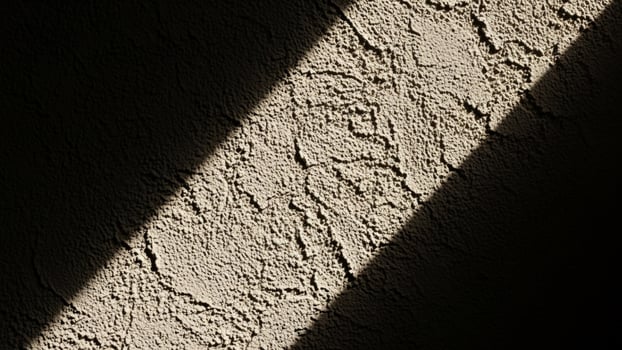 A shadow of a wall with a light coming through it photo