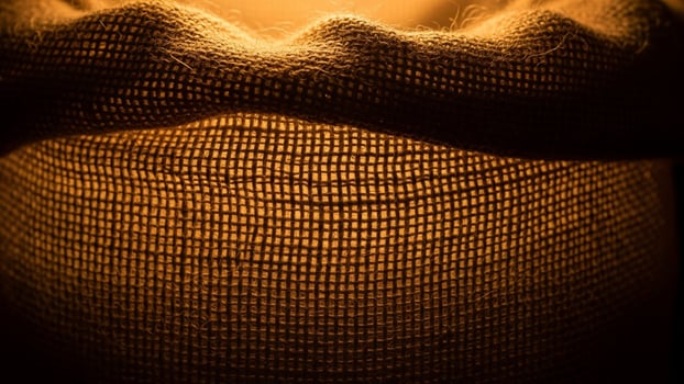 A close up of a lit candle in a sack photo