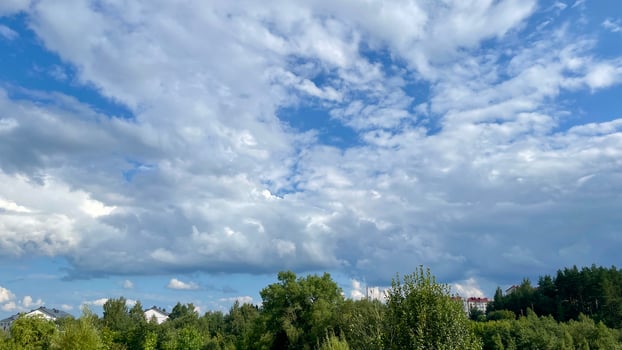 A view of the sky with clouds and trees photo