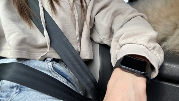 A woman sitting in the back seat of a car with her hand on her wrist photo