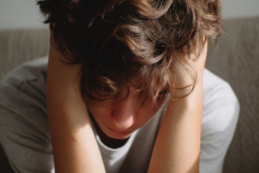 Young person suffering from headache, holding head in hands photo