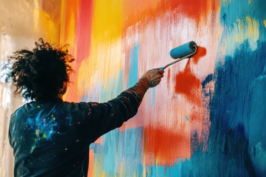 A person painting a colorful wall with a roller photo