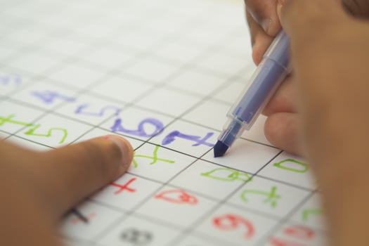 Child uses colored markers for math activity photo