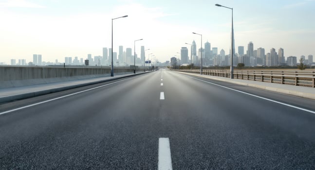 Empty Highway Leading to a Distant, Hazy City Skyline Under a Bright Sky photo