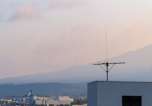 TV Antenna Installed on building rooftop. Old style analog TV ariel in sunrise sky. photo